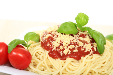 Spagetti z sosem bolońskim serem, pomidorami i zielonymi listkami bazyli. - obrazy, fototapety, plakaty