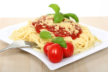 Spagetti z sosem bolońskim serem, pomidorami i zielonymi listkami bazyli. - obrazy, fototapety, plakaty