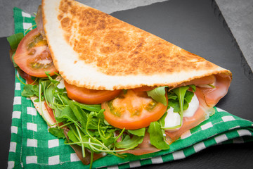 typical piadina romagnola with ham, cheese and rocket