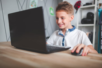 Excited preteen boy using laptop in his room at home © leszekglasner