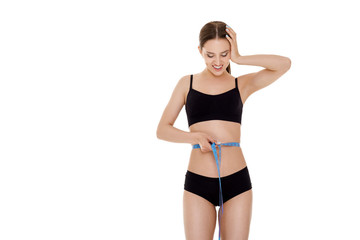 Obraz premium woman measuring waist with blue measuring tape.
