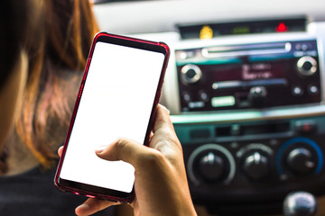 Hand holding smartphone with white screen in the car for mock up design. hand hold using smartphone for finding location.