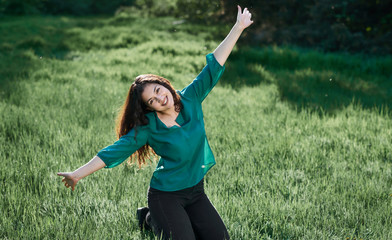 beautiful woman posing on green grass at sunny day, summer forest, bright landscape with shadows