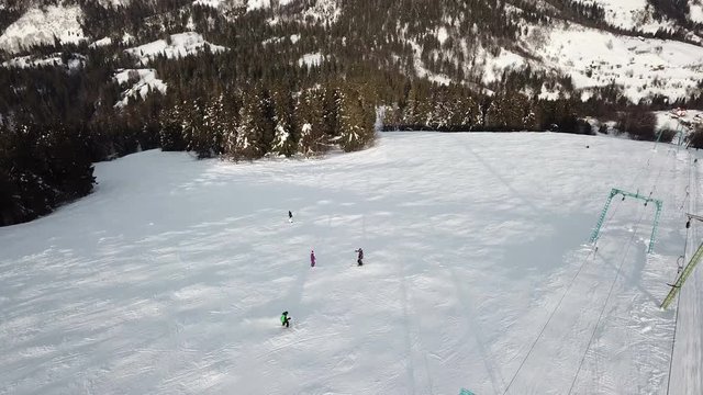 Aerial.  Skiers silhouettes on ski lift.