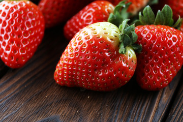 Fresh strawberries on brown wooden background. A group of strawberries