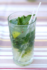 Fresh mojito from mint and lime in a glass on the table.
