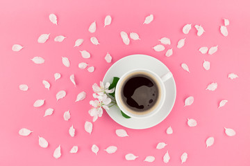 Flat lay of coffee and white flowers petals