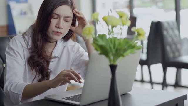 woman under a lot of stress using laptop computer in cafe