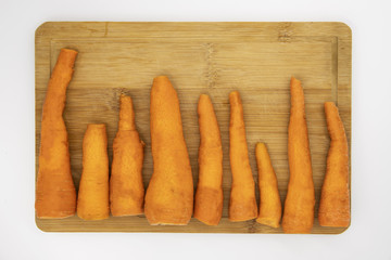 Juicy orange carrot on cutting board top view photo. Many carrots cleaned for cooking.