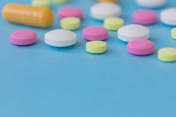 Medication, colourful pills, flat lay on blue background