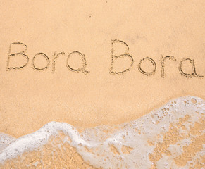The word Bora Bora written in the sand on beach