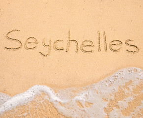 The word Seychelles written in the sand on beach