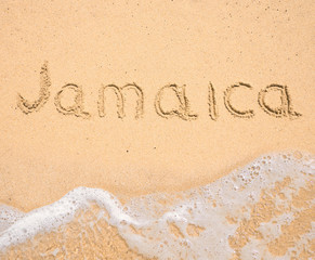 The word Jamaica written in the sand on beach
