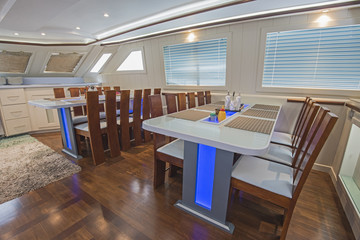 Interior of large salon dining area of luxury motor yacht