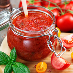 Tomato sauce in a glass jar and ingredients.
