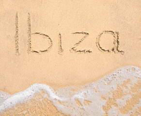 The word Ibiza written in the sand on beach
