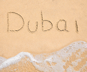 The word Dubai written in the sand on beach