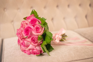 Wedding bouquet of pink roses on the couch.