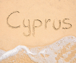 The word Cyprus written in the sand on beach