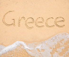 The word Greece written in the sand on beach
