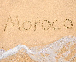 The word Moroco written in the sand on beach