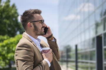 Businessman with smart phone outdoors