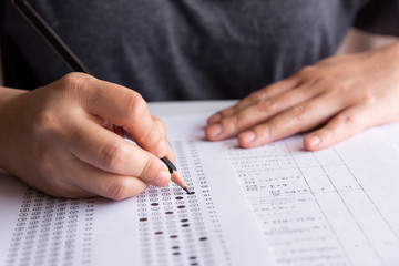 Exam. Students holding pencil writing selected choice on answer sheets and Mathematics question sheets. students testing doing examination. school exam	 - obrazy, fototapety, plakaty