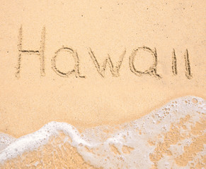 The word Hawaii written in the sand on beach