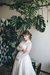 pretty woman in a wedding dress in the depressions of living plants.