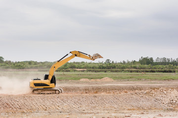 Yellow excavator machine working earth moving works at construction site