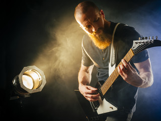 Guitar player in front of spotlight