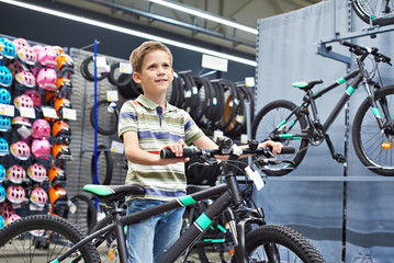 Fototapeta na wymiar Boy and bicycle in sport shop