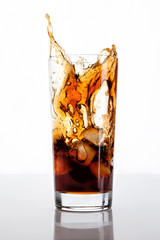 glass of cola with ice and splashes