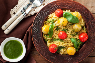 Spaghetti with stewed tomatoes, pesto, basil