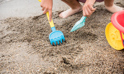 boy playing on the seashore with beach toys