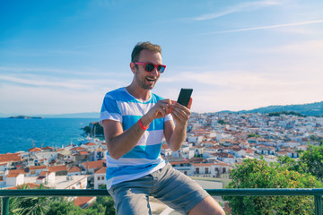 Modern man using cellphone outdoors.