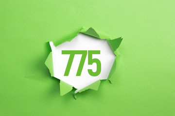 gruene Nummer 775 auf gruenem Papier