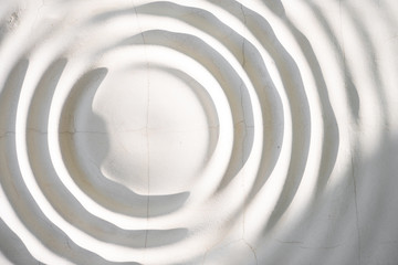 Gypsum texture of the wall with a pattern of circles. Daylight and shadows. Abstraction.