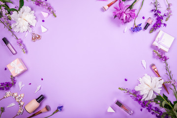 Set of cosmetics, brushes and jewellery with fresh flowers on purple background. Summer sale....