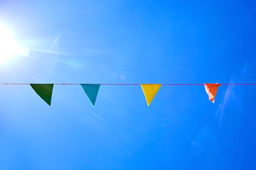 Multicolored festival flags on blue sky background