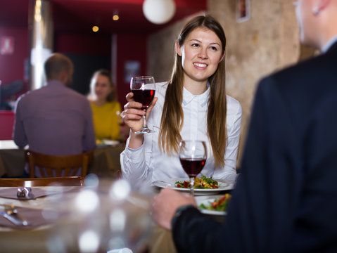 Adult girl with man enjoying meal at restaurant