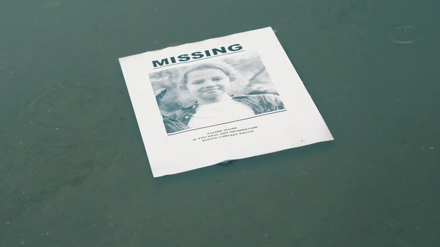 Concept,leaflet about missing child is floating in a puddle