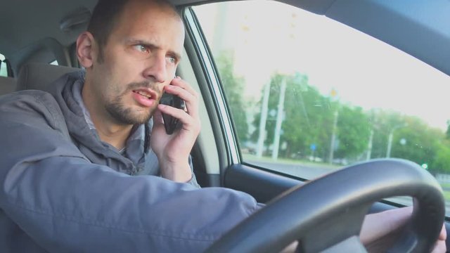 Irresponsible man driving car and speaking on mobile phone