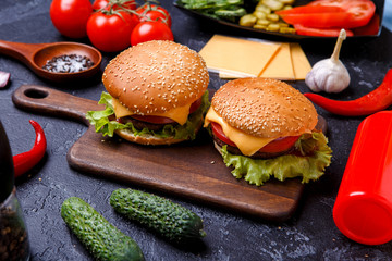 Image of two hamburgers on wooden board, cheese