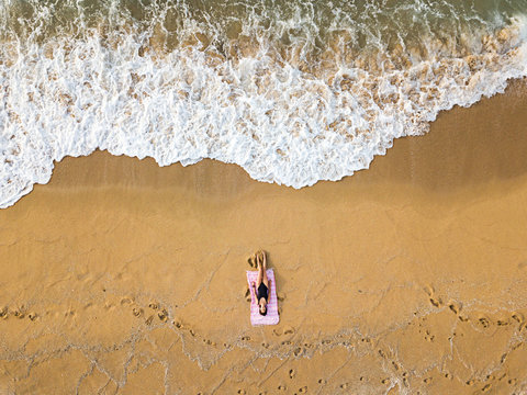 Woman sunbathing alone on an empty beach