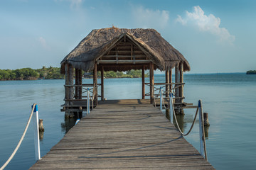 Muelle y choza de madera en un lago con  cielo azul