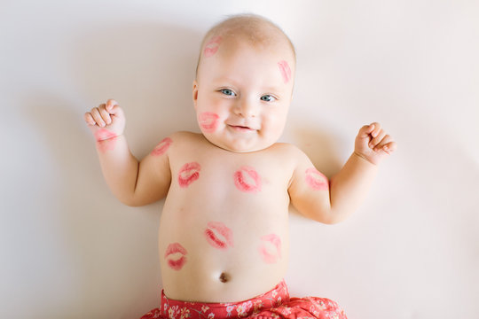 Image of adorable child with red kisses on the skin, happy baby girl isolated on white background, little love angel, romantic holiday, Valentines day concept