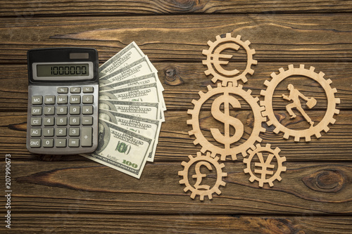 Calculator American Dollar Banknotes Of Currency Signs Businessman Calculator American Dollar Banknotes Of Currency Signs Businessman Runs In Gears On A Wooden
