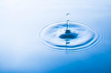 Water drop falling into water make waves. Water splash or water drop background.