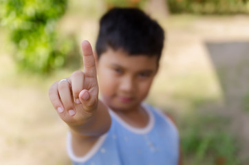 Boy points a finger or giving a number one signal